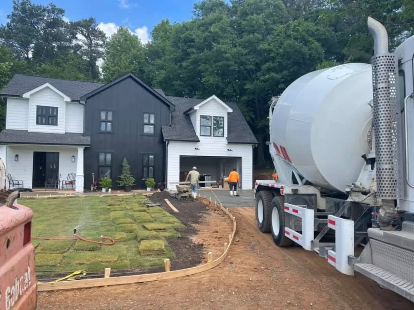 Concrete mixer truck on site at a newly built home with fresh sod going down