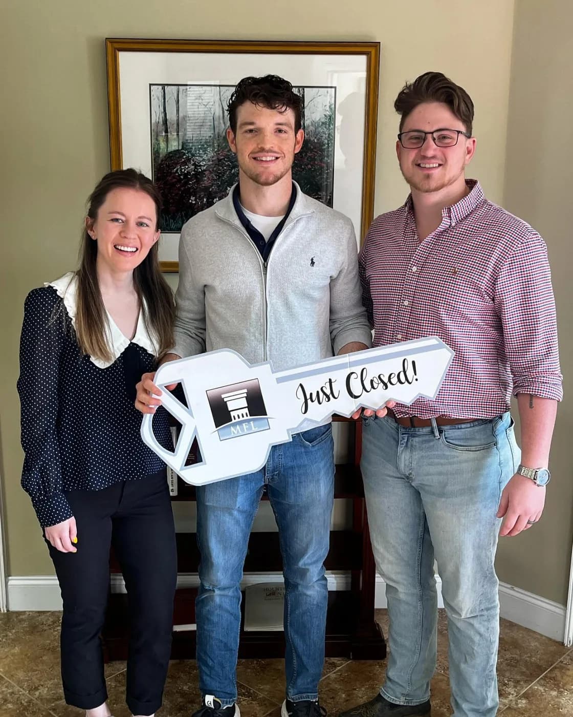 Couple holding a Just Closed key with Andrew at the closing table