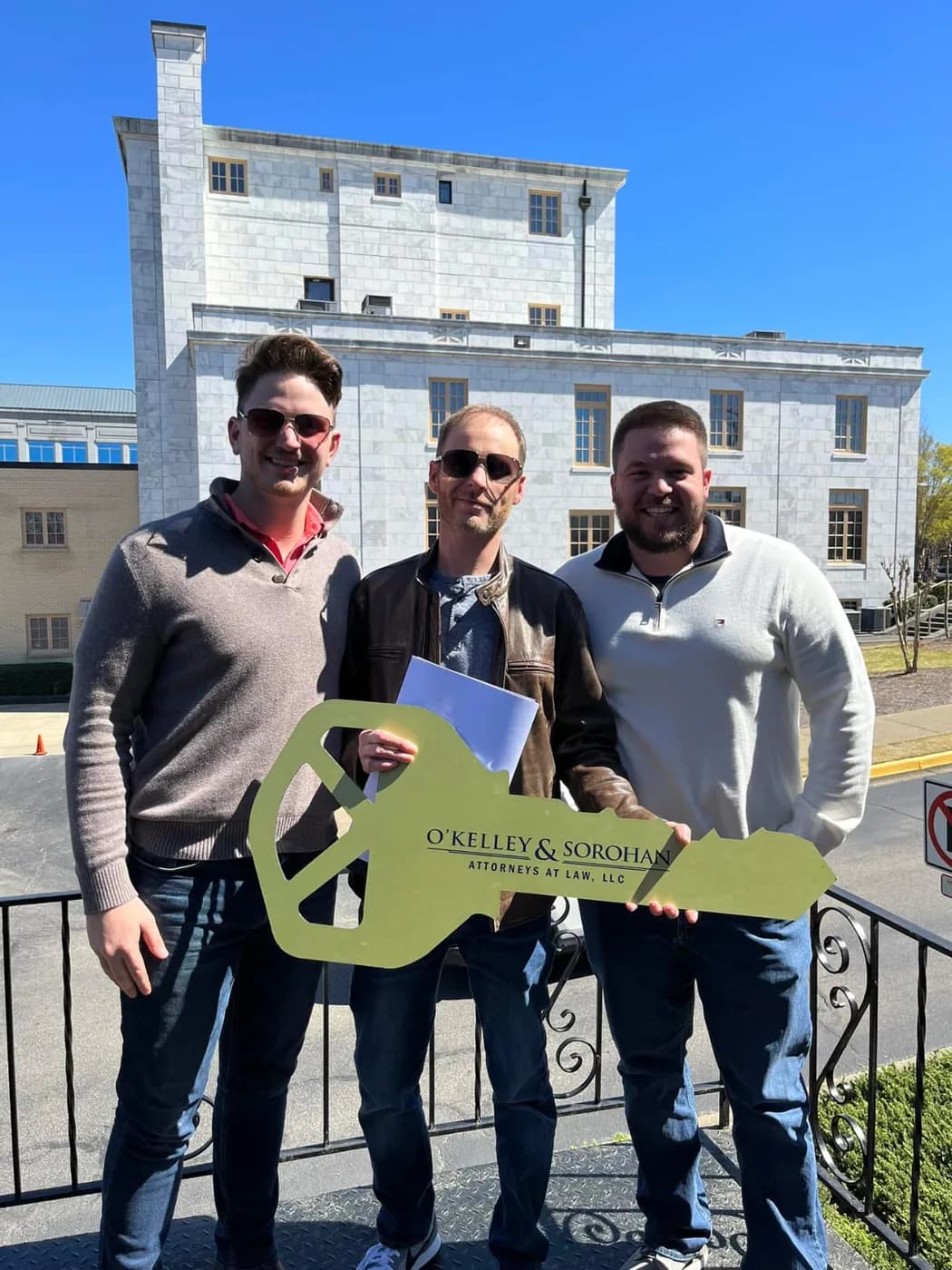 Buyers holding an oversized key outside the closing office